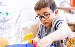 Little boy playing with play carpenter tool set