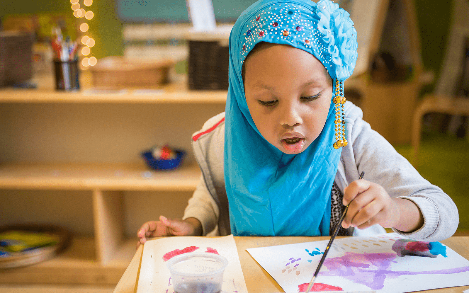 Little girl painting with watercolors