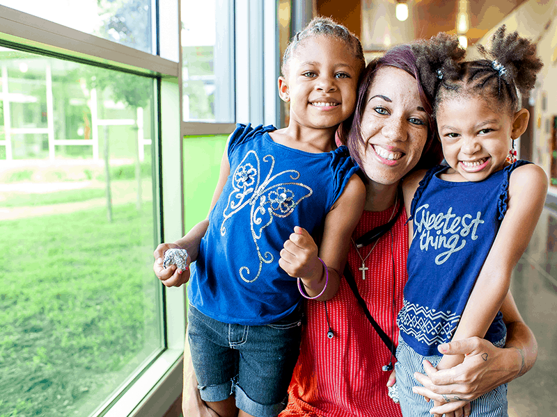 Mother and daughters smiling