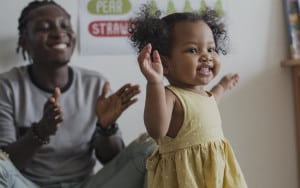 Parent clapping as child learns to walk