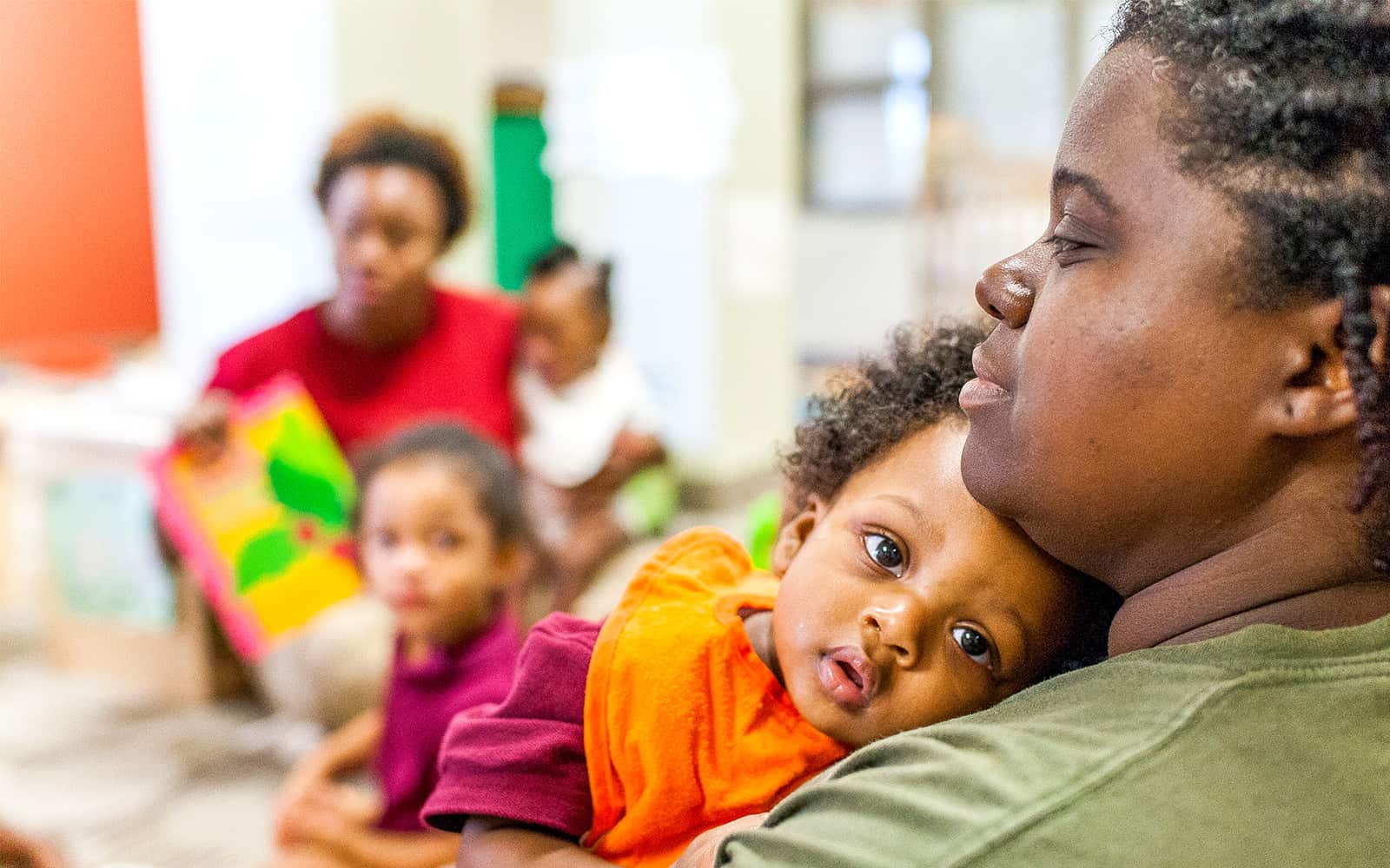 Mother holding child in classroom