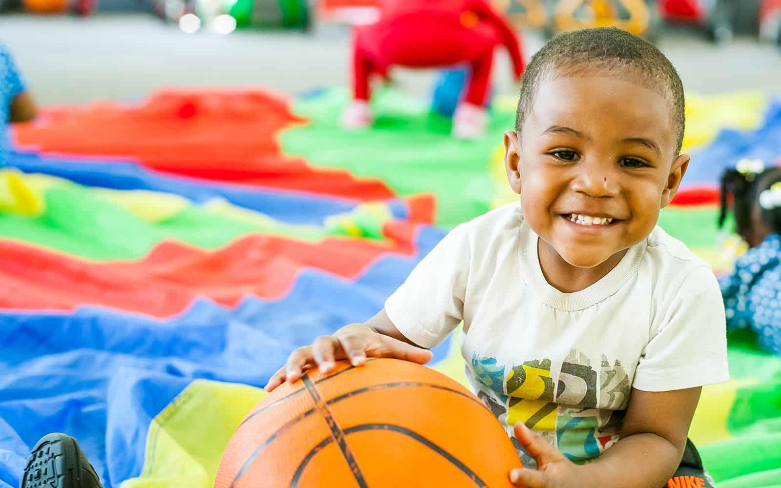 Educare boy smiling holding basketball