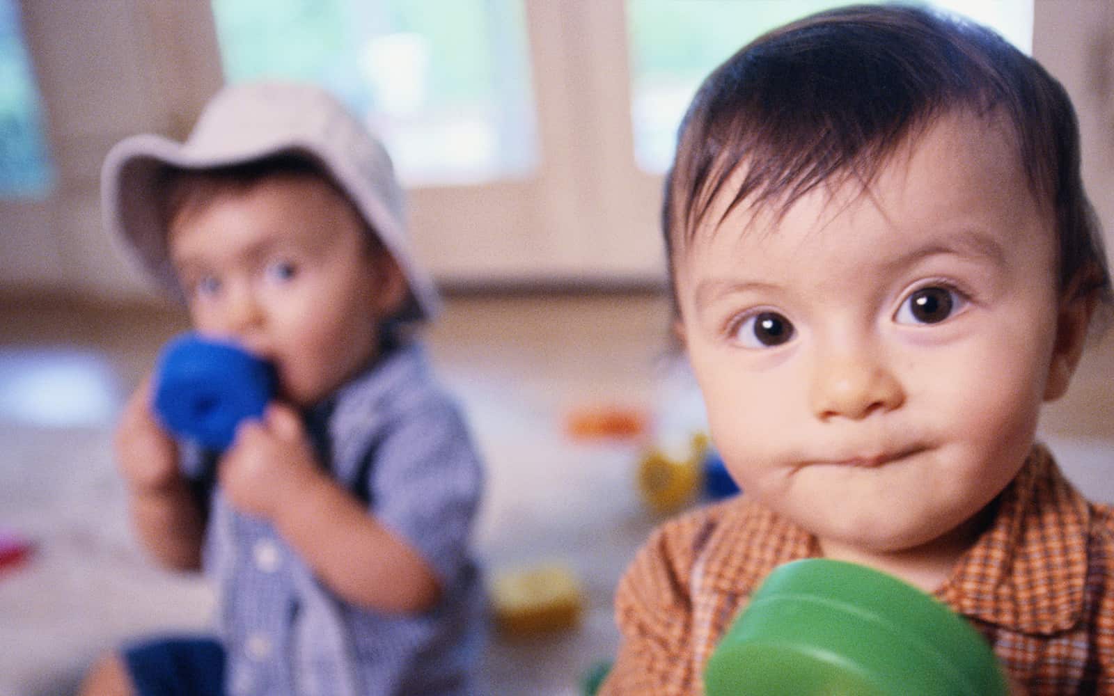 Little boy in orange shirt with green toy