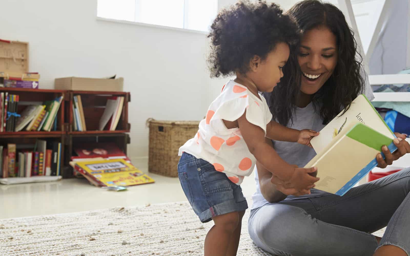 Toddler girl reading with her mom