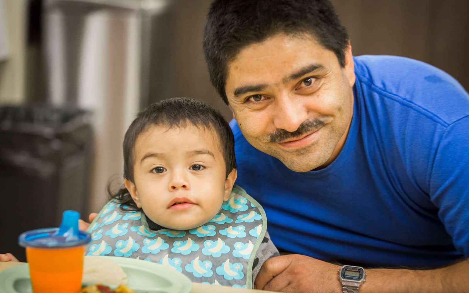 Infant boy eating with dad