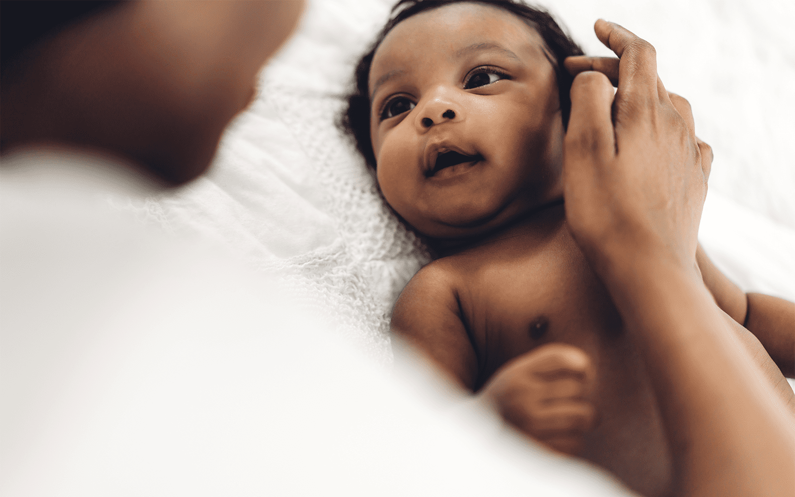 Newborn smiling at mom