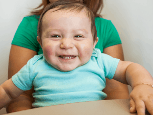 Baby smiling and looking directly at camera 