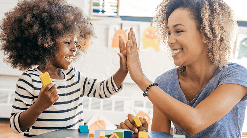 Child and teacher high fiving