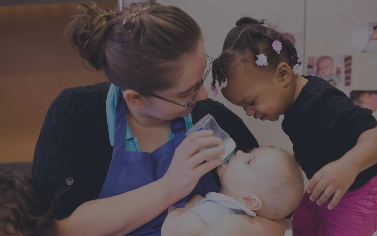 Early childhood professional caring for baby and toddler