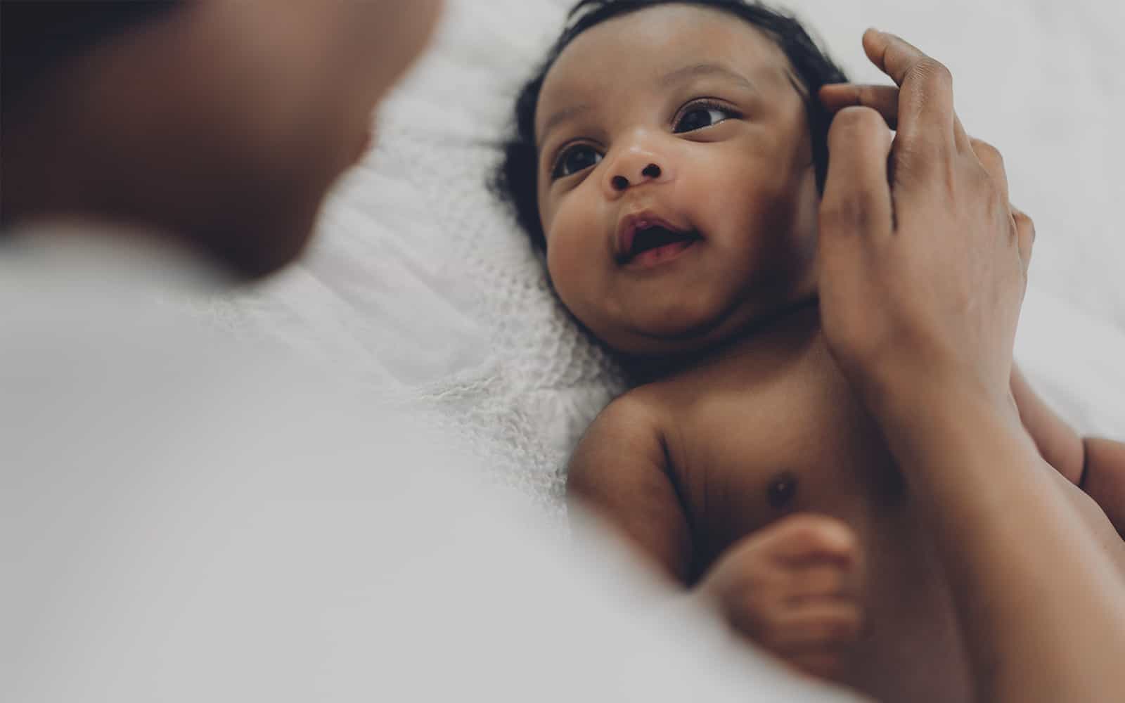 Mother touching newborn's cheek