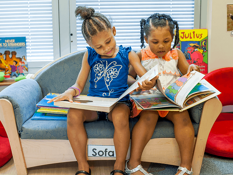 Two girls reading on couch