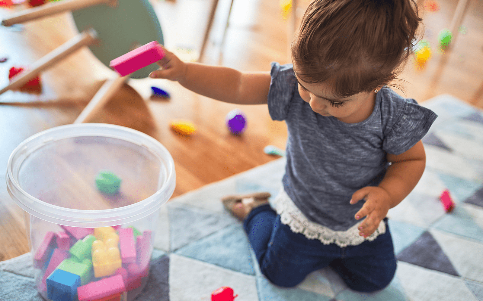 Young girl putting away blocks