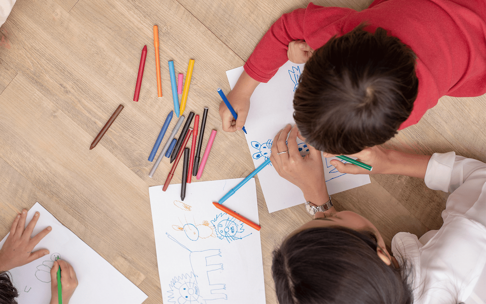 Young child and teacher drawing together