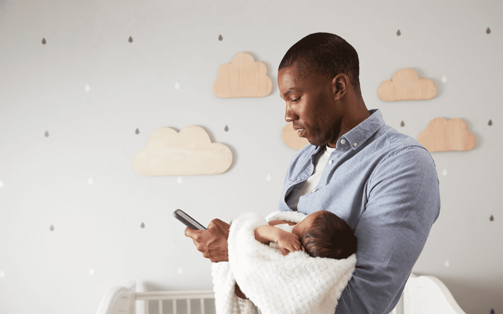 Father holding child and looking up article on phone