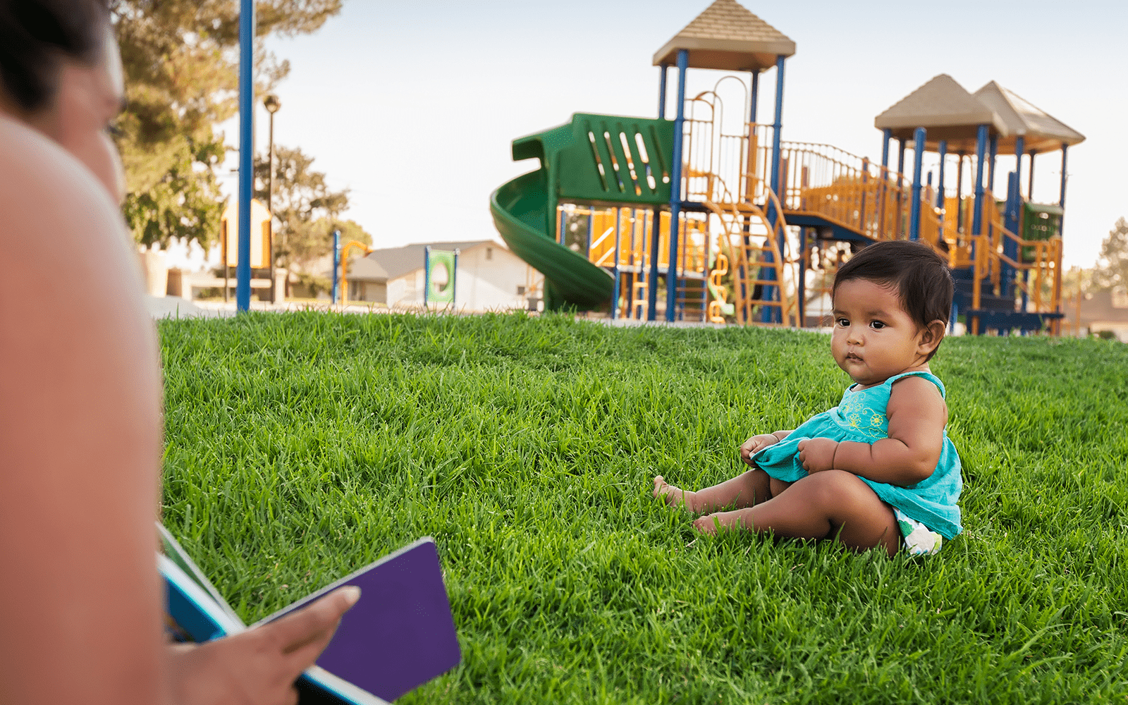 Baby and Mother on Green Grass by Playground