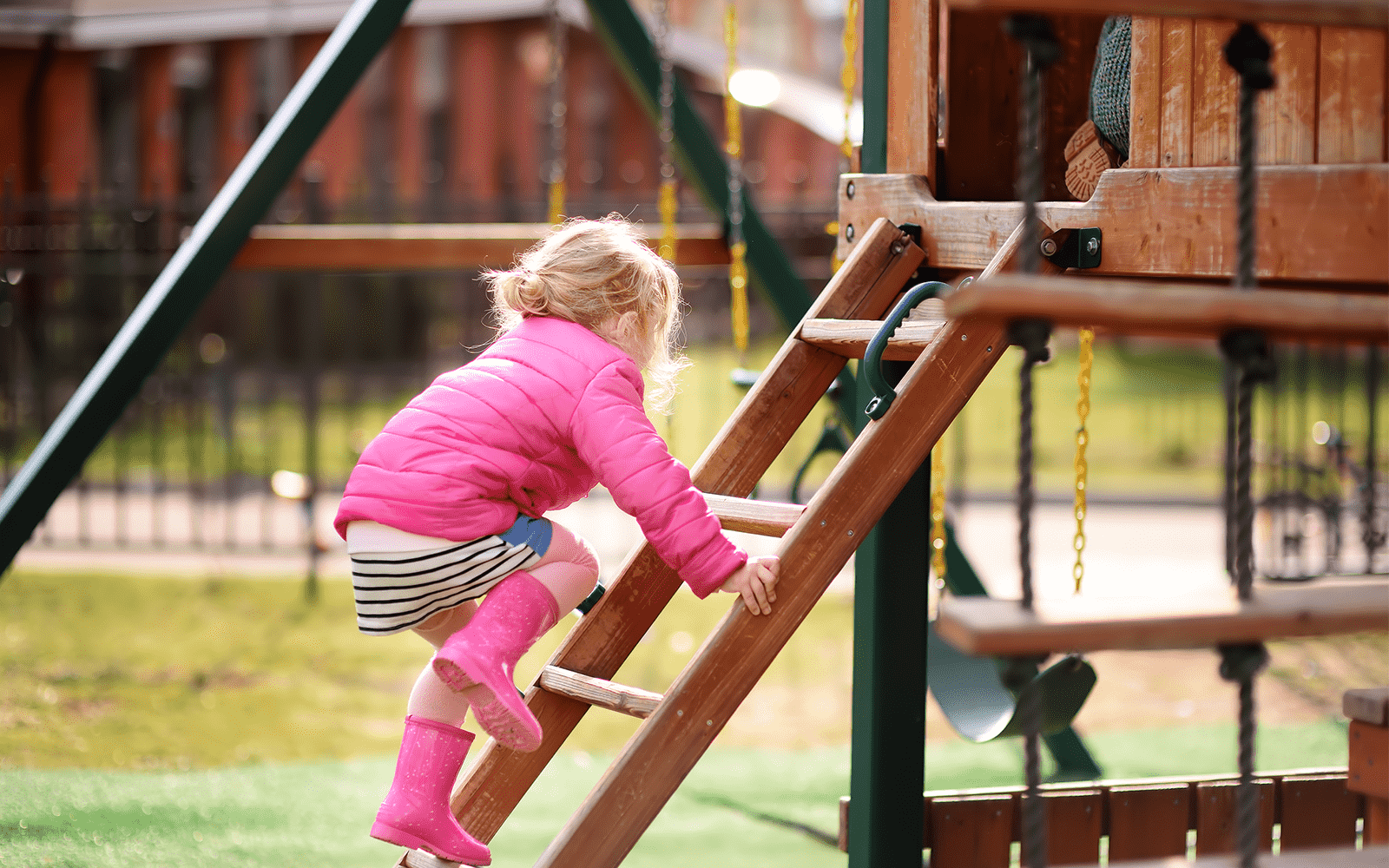 Little Girl in Pink Rain Boots on Playground