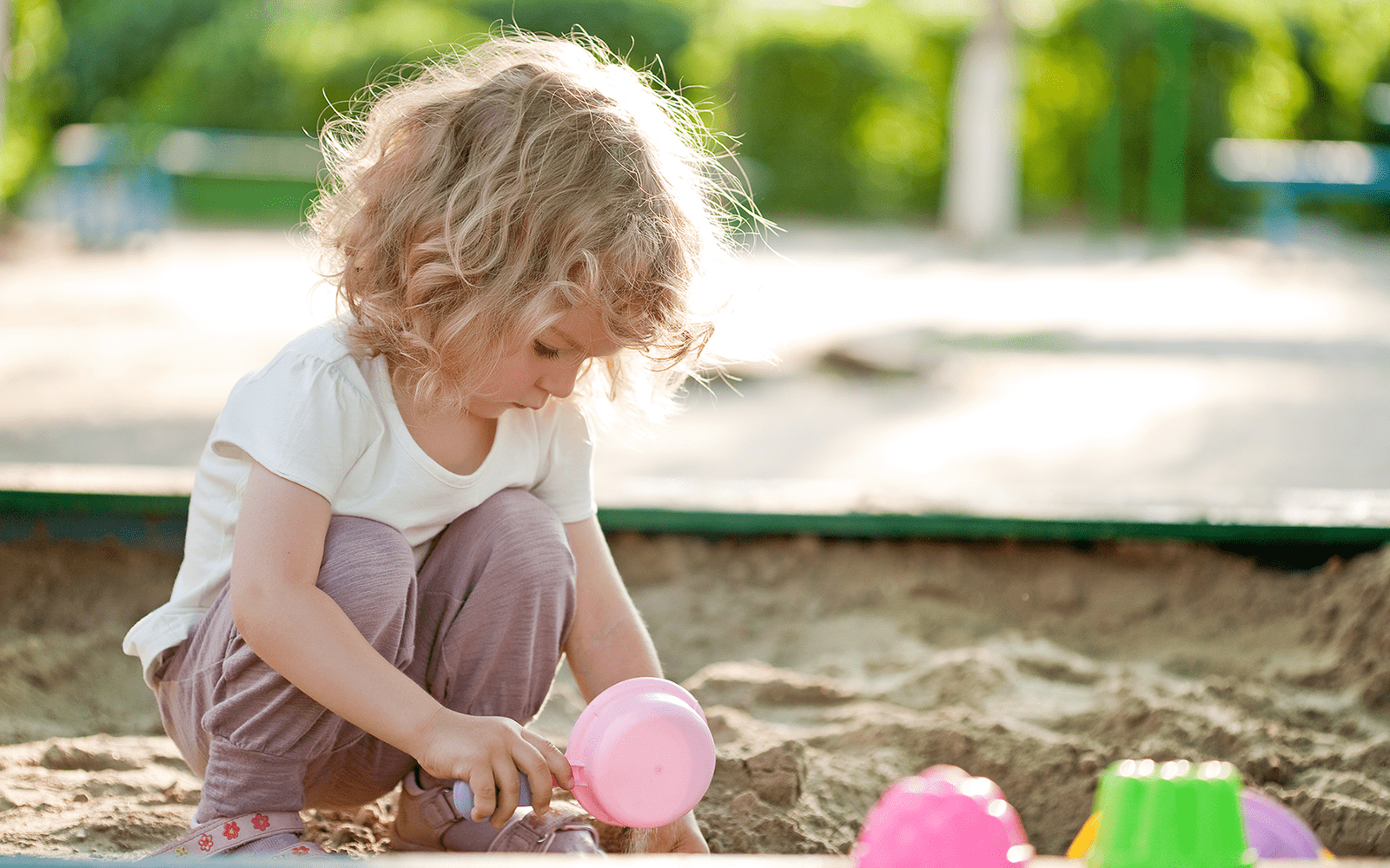 Little Girl Plays in Sandbox
