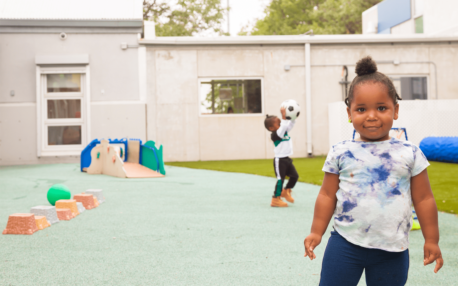 Young girl smiling and looking at camera at outdoor playgorund