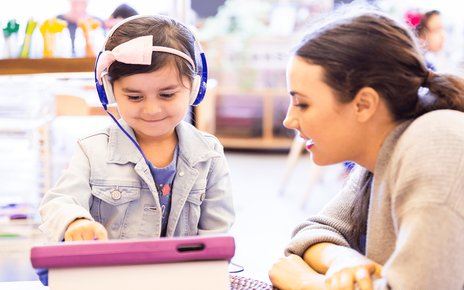 girl and teacher with headphones and tablet