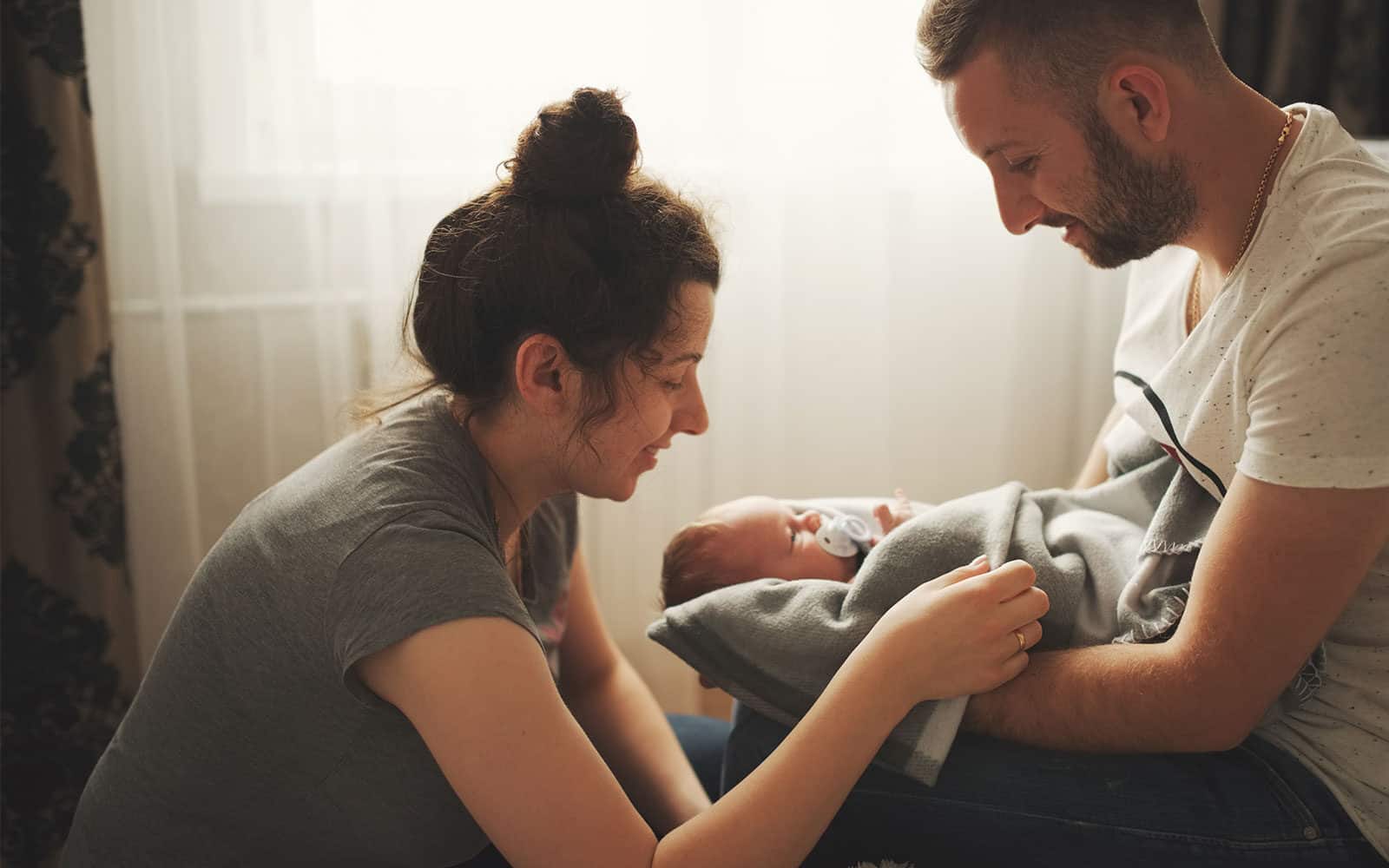 New parents holding their newborn baby