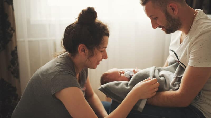 New parents holding their newborn baby
