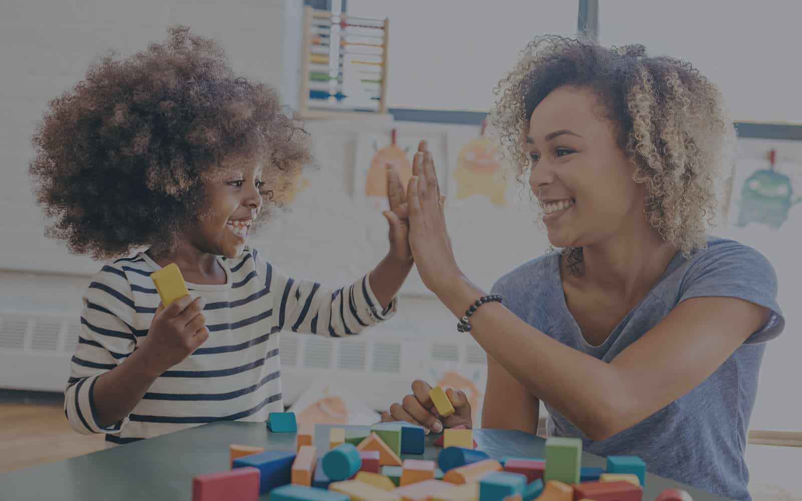 Teacher and student high fiving in classroom