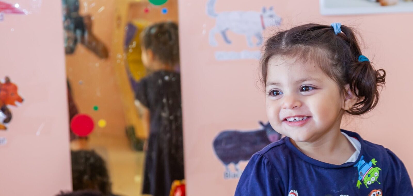 Small Child smiling and looking to their right side at school center