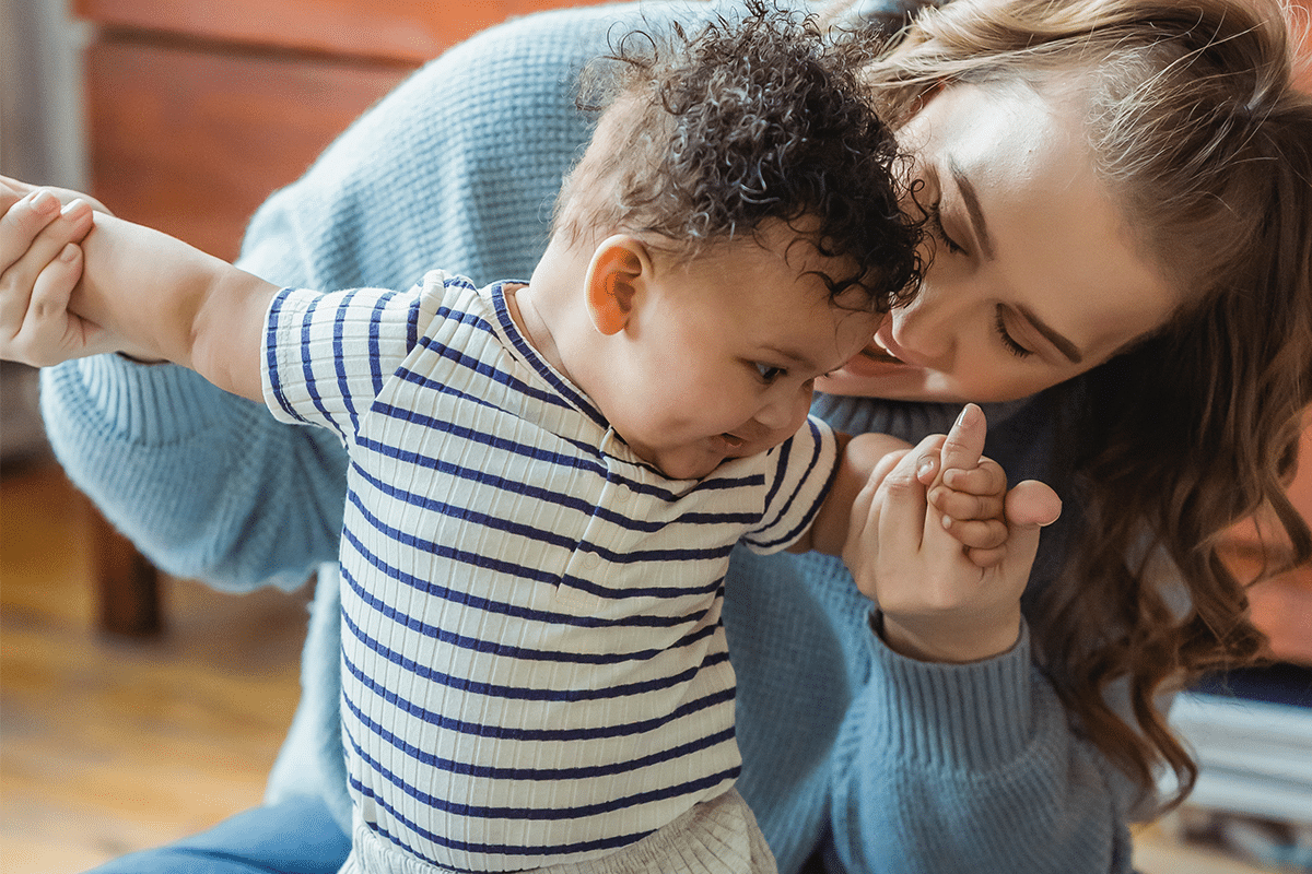 mother helping child stand up