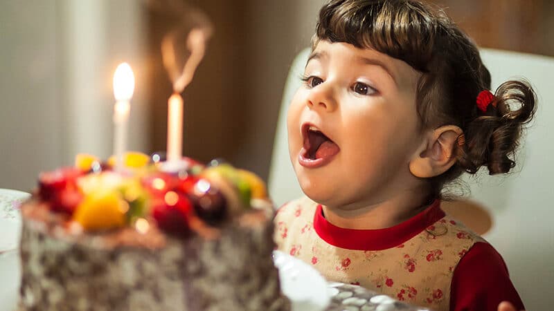 Child blowing out birthday candles