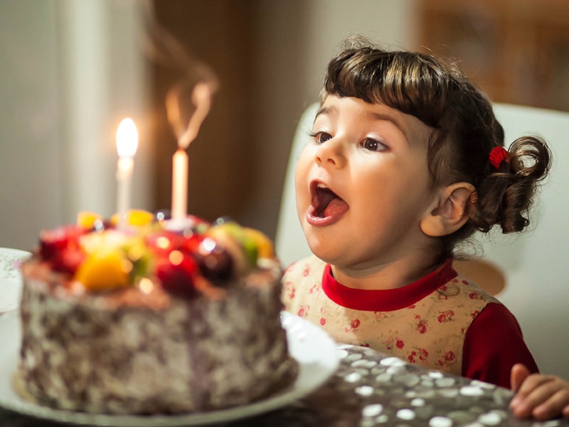 Child blowing out birthday candles