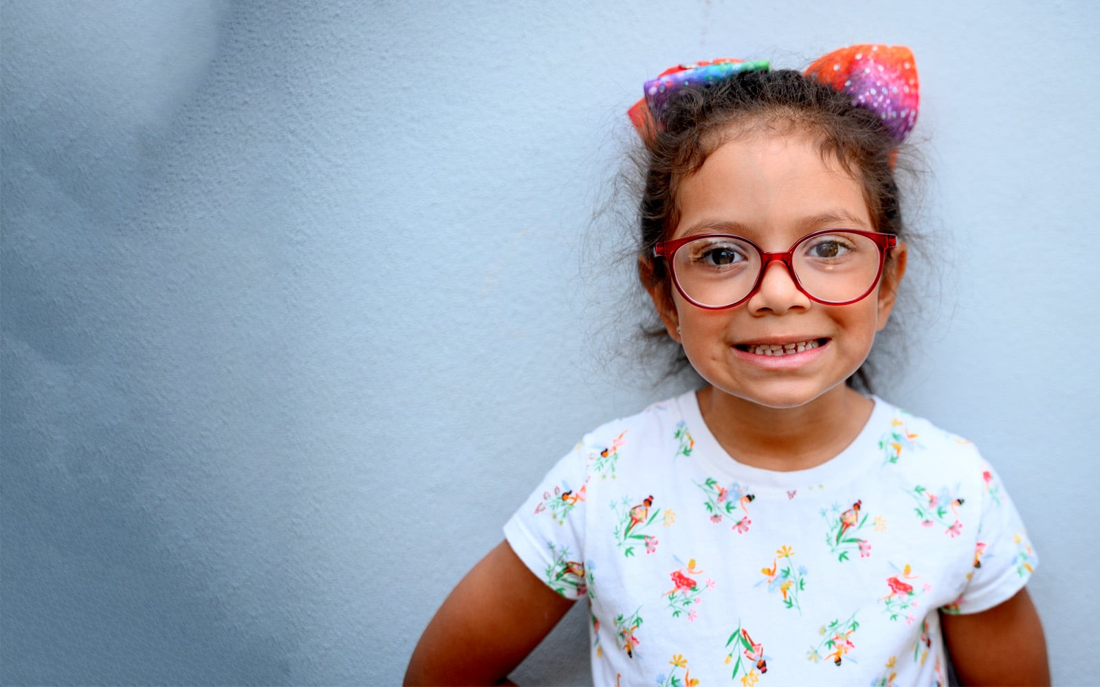 Educare Miami student smiling while standing against the wall