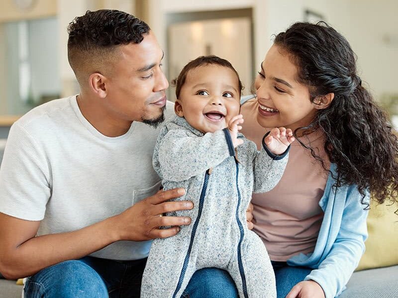 A Mother and father looking at their child with joy