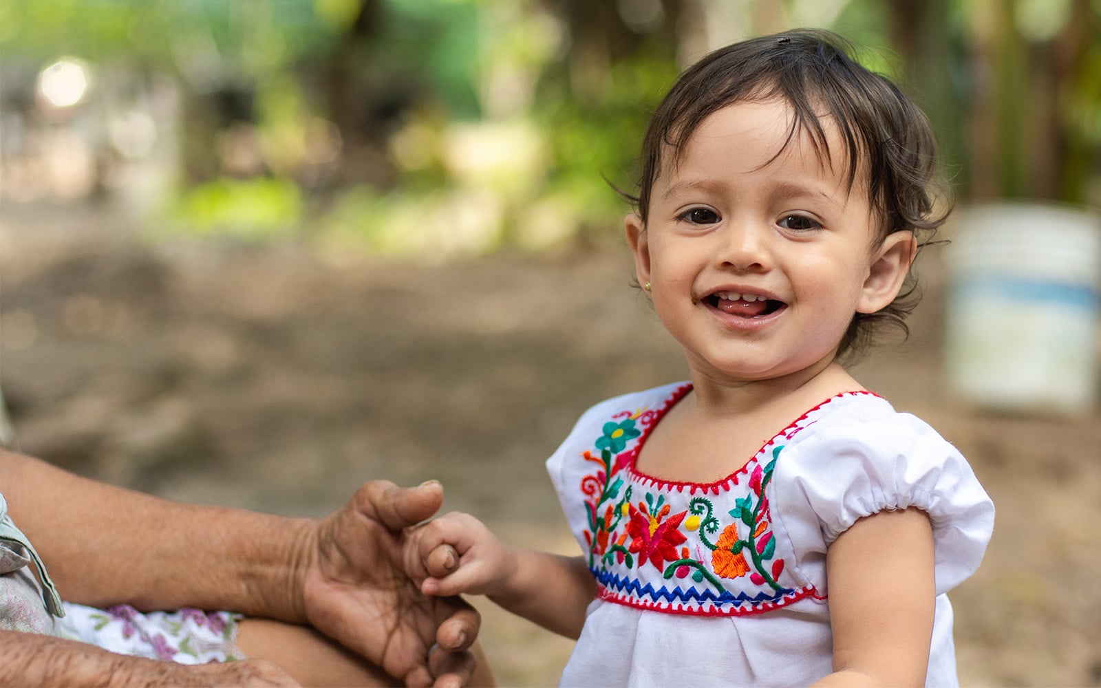 Young child holding her grandmother's hand