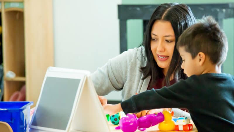 Teacher assisting child in a learning activity