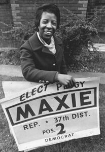 Peggy Maxie holding "Elect Peggy" campaign poster
