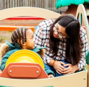 Teacher speaking with child on playground