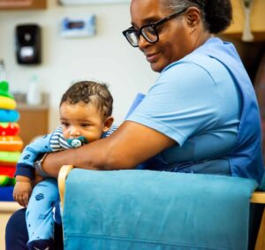 Teacher holding infant