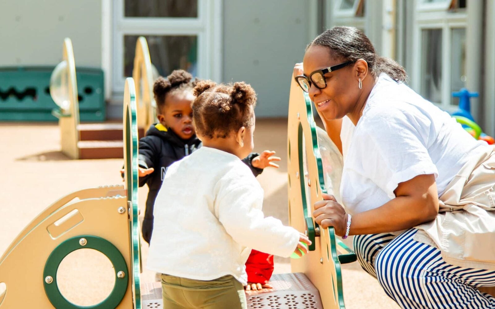 Children playing with teachers outside