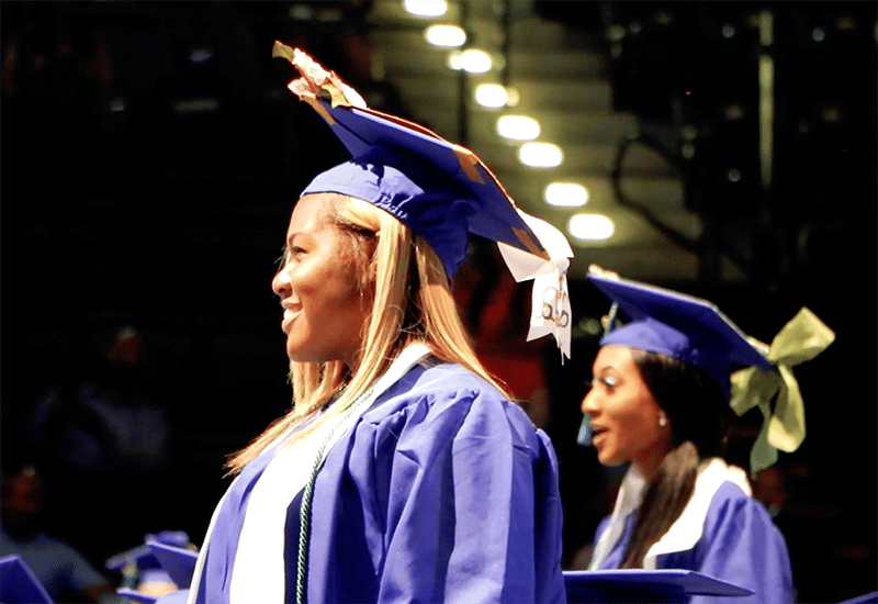Image of a graduate in purple robes.