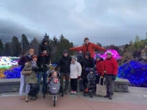 Bamford family photo in front of an outdoor lights display in the Winter.