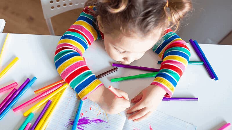 Little girl coloring with color pencils