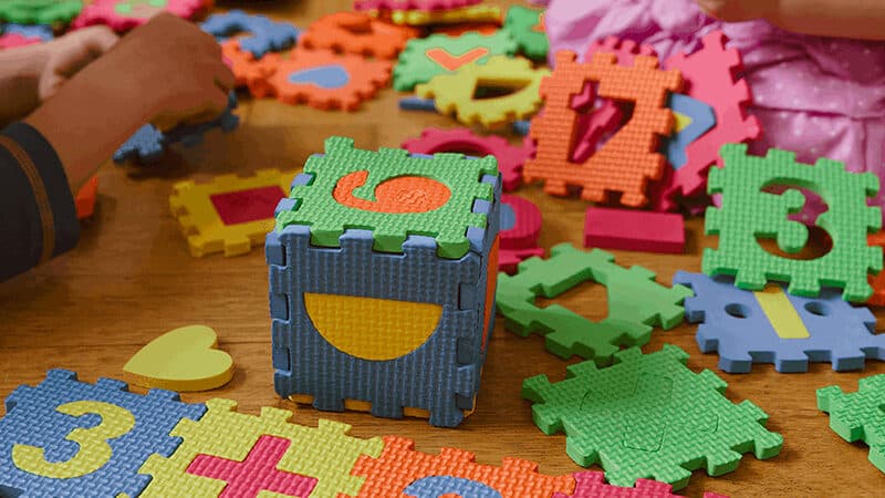 Children playing with counting soft puzzle block pieces